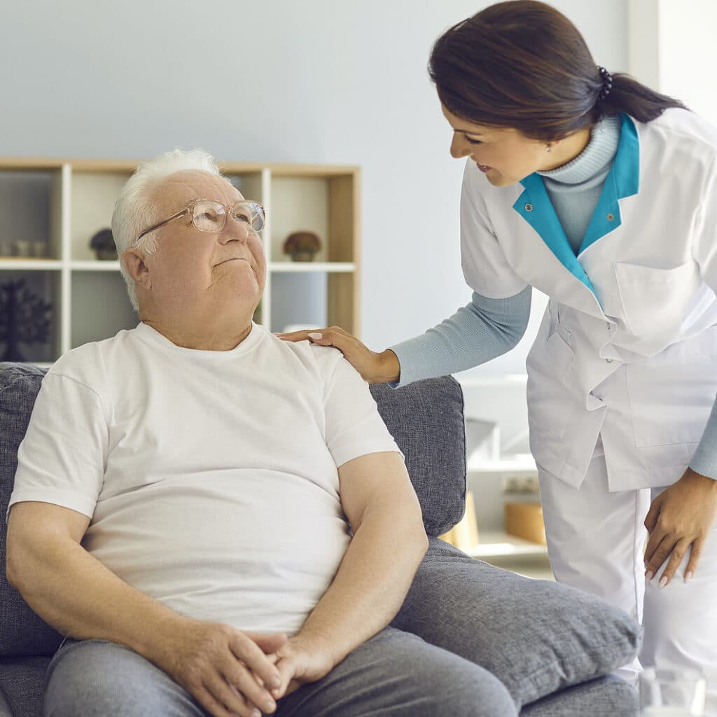 Friendly doctor or helpful nurse comes to see senior patient at home or in assisted living facility